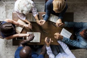 Group of people holding hands praying worship believe