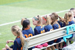 team of girls on soccer bench