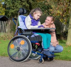 Disabled child with caregiver going for walk